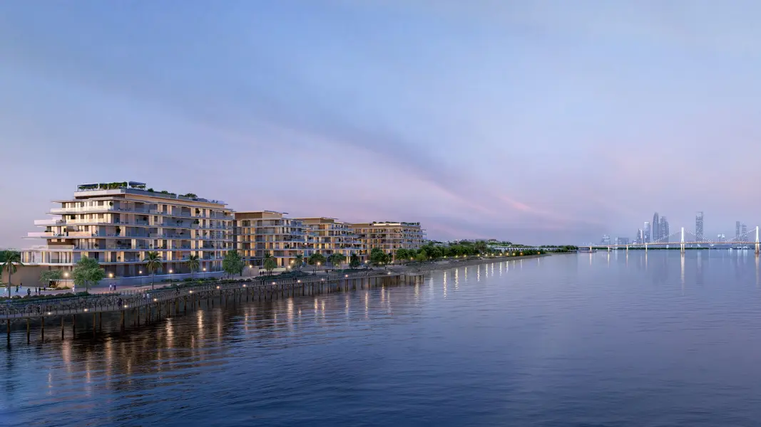 Bashayer Residences waterfront facade at dusk with the Abu Dhabi skyline beyond